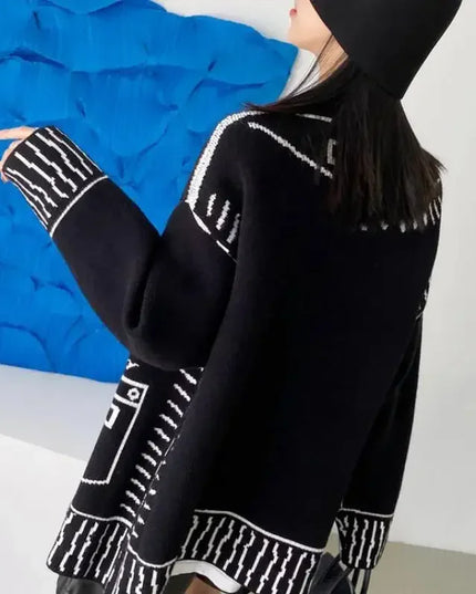 Schwarzer Strickmantel mit Graffiti-Print, getragen mit Hose