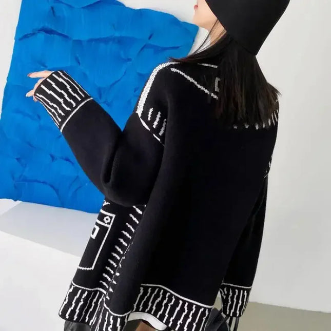 Schwarzer Strickmantel mit Graffiti-Print, getragen mit Hose
